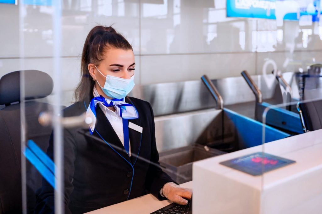 Female check-in agent sits at the counter for checking documents